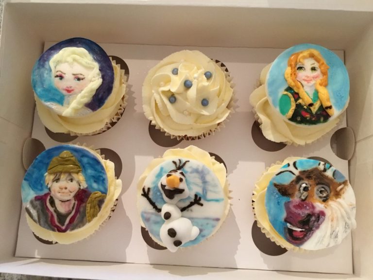 Character cupcakes. Vanilla cupcakes topped with piped vanilla buttercream with hand-painted sugar plaques.