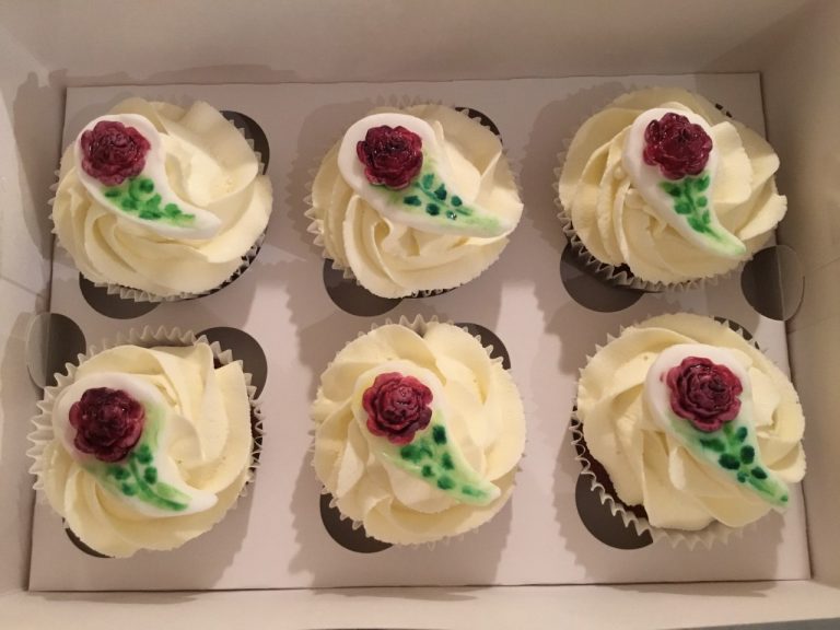 Cupcakes with vanilla flavoured buttercream, topped with moulded, hand-painted dark red rose sugar decorations