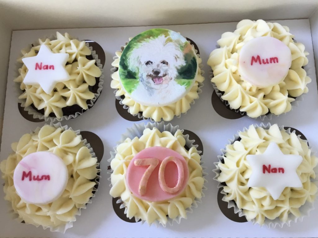 Vanilla cupcakes with hand painted Bichon Frise dog decoration.