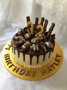Vanilla buttercream cake with dark chocolate drip and sweet treats