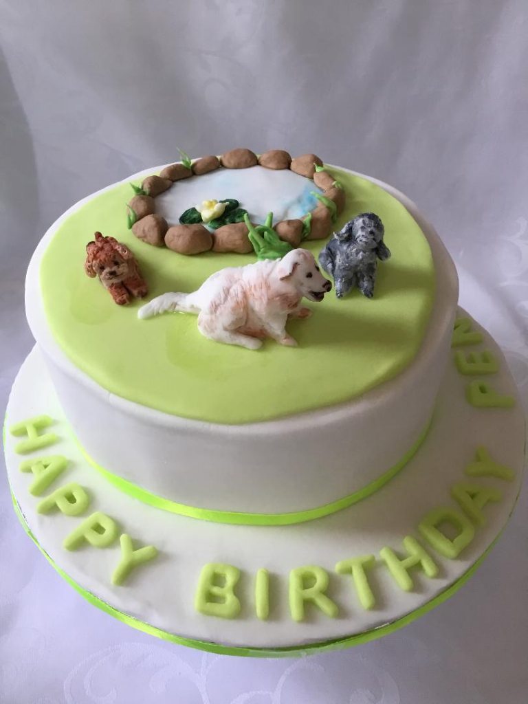 White iced cake with dogs sugar decorations.