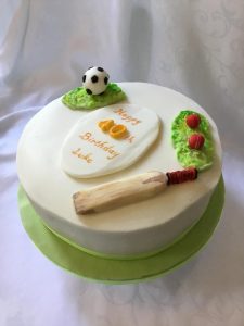 Night Owl Cakery - White iced 10 inch wide birthday cake with sports themed decoration..